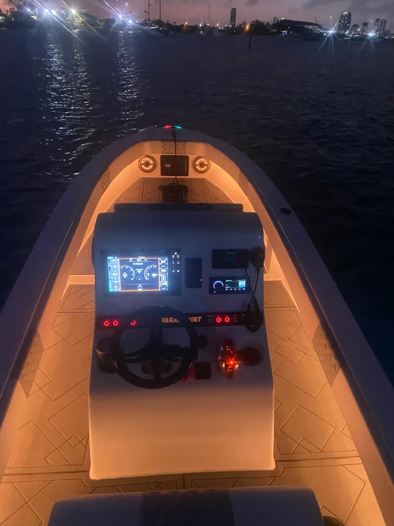 Slide: The Image of 1987 Paramount 21 boat dashboard illuminated at night on the water. - 12