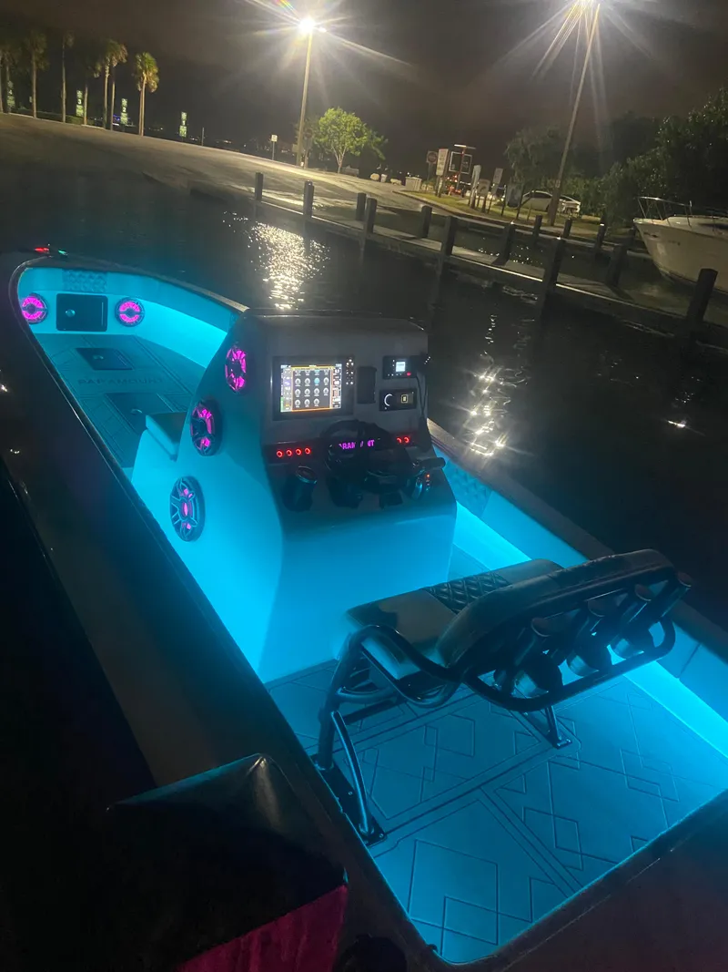 Slide: The Image of 1987 Paramount 21 boat with illuminated interior and modern dashboard at night. - 14