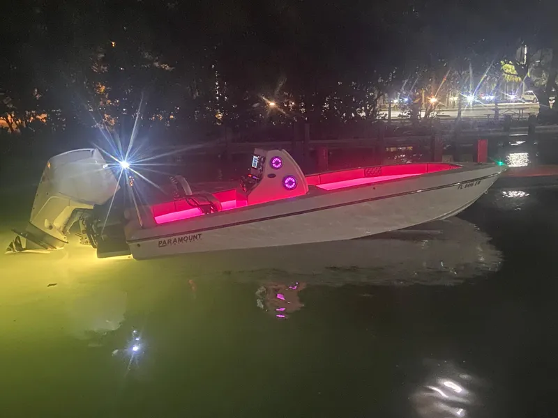 Slide: The Image of 1987 Paramount 21 boat with vibrant pink interior lights, docked at night. - 17