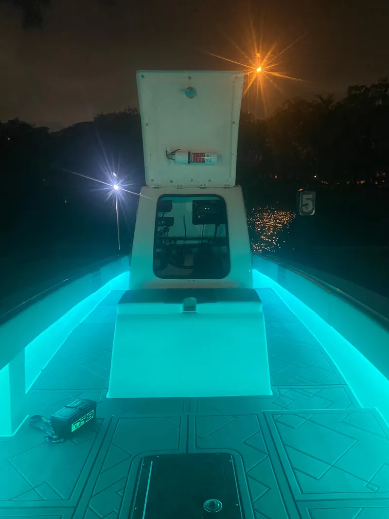 Slide: The Image of 1987 Paramount 21 boat with glowing blue interior lights at night. - 18