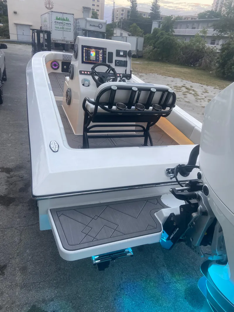 Slide: The Image of 1987 Paramount 21 boat with modern console and seating, docked on a concrete surface. - 20