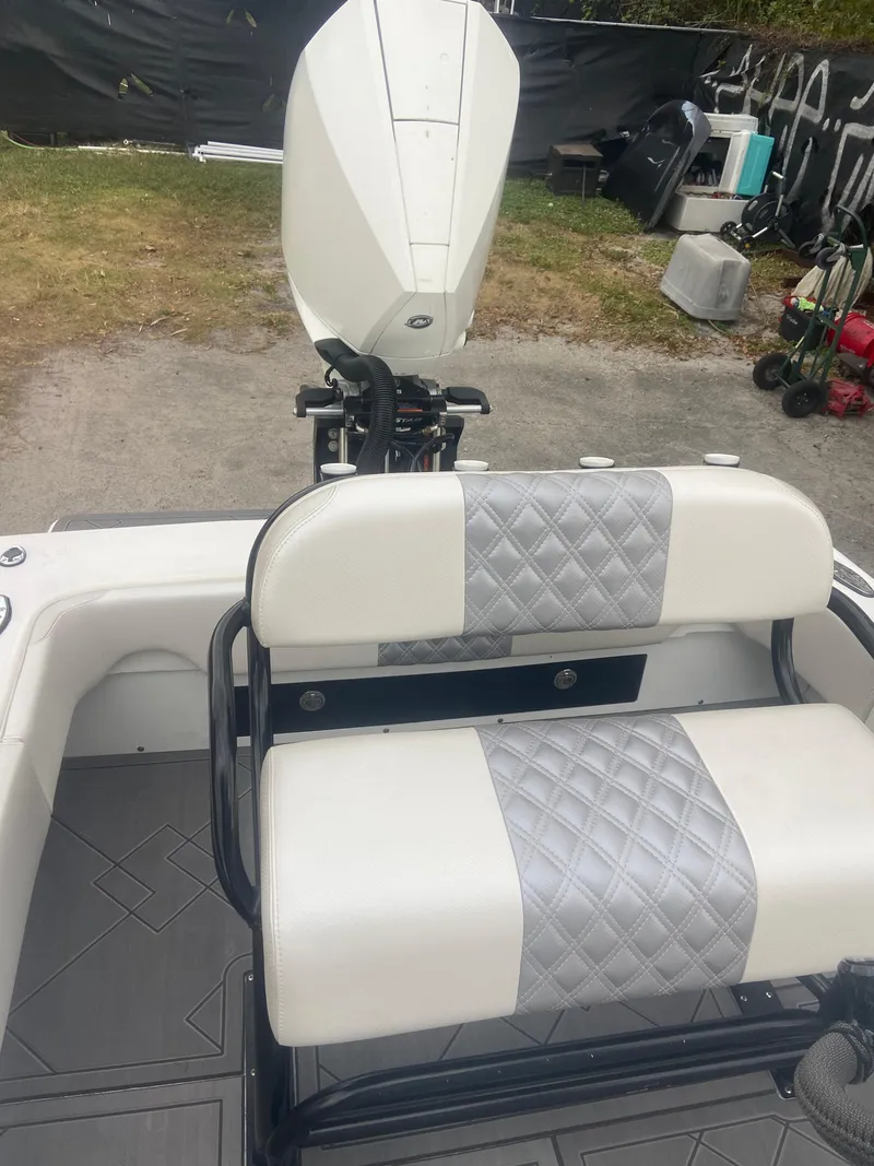 Slide: The Image of 1987 Paramount 21 boat with white and gray seating, outboard motor visible. - 22