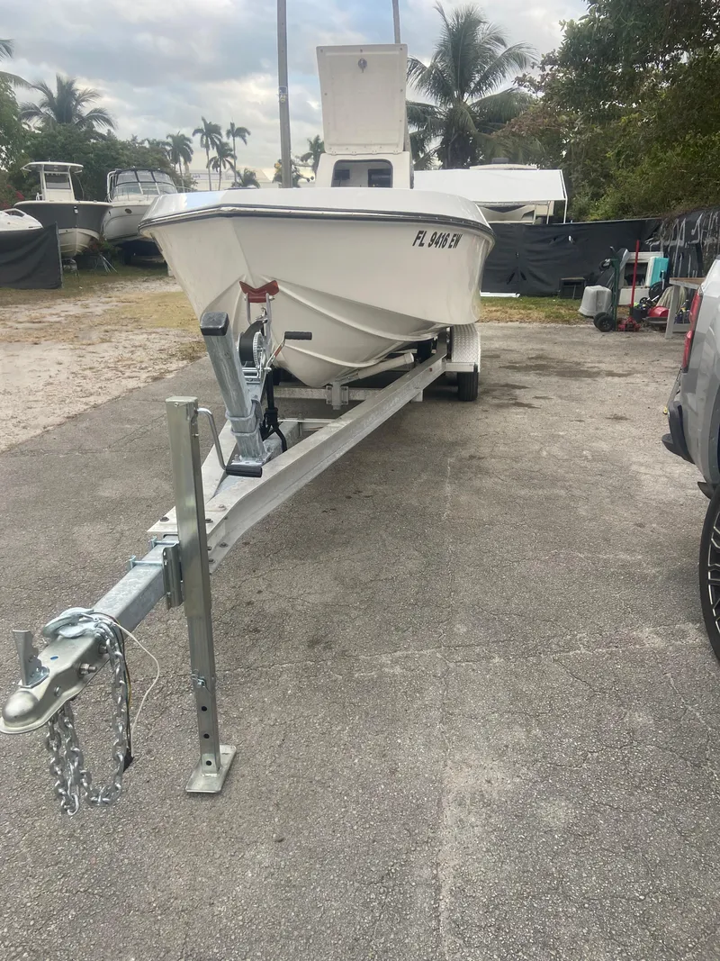Slide: The Image of 1987 Paramount 21 boat on trailer, parked outdoors with palm trees in background. - 27