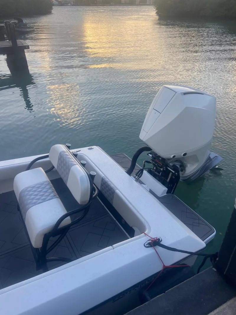 Slide: The Image of 1987 Paramount 21 boat with outboard motor on calm water at sunset. - 8