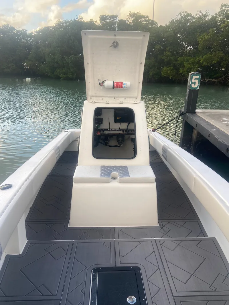 Slide: The Image of 1987 Paramount 21 boat with open storage hatch, docked by a serene waterway. - 9