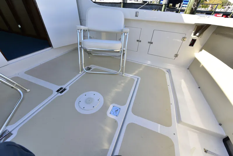 Slide: The Image of 1998 Duffy 35 Downeast Cruiser deck with chair and storage compartments. - 10