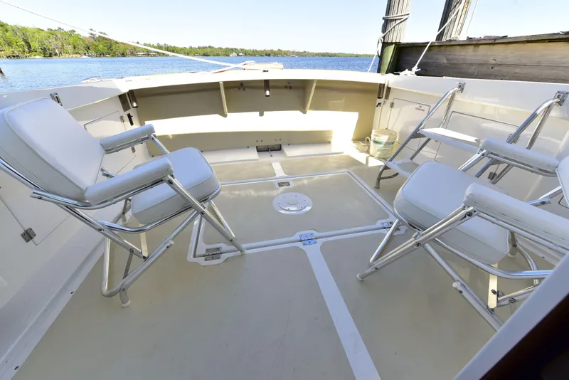 Slide: The Image of 1998 Duffy 35 Downeast Cruiser deck with seating, overlooking serene water. - 11