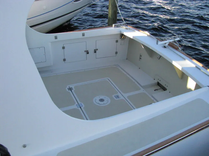 Slide: The Image of 1998 Duffy 35 Downeast Cruiser boat deck with storage compartments, docked on water. - 12