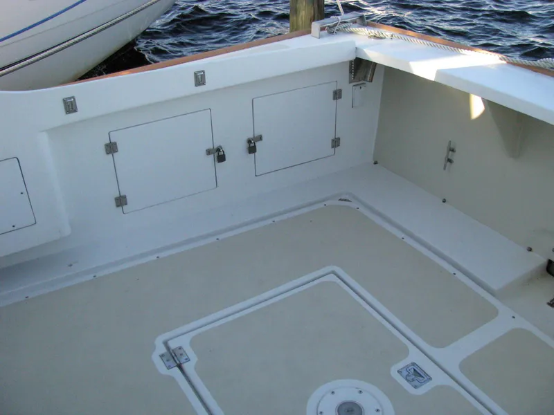 Slide: The Image of 1998 Duffy 35 Downeast Cruiser deck with storage compartments, docked by the water. - 13