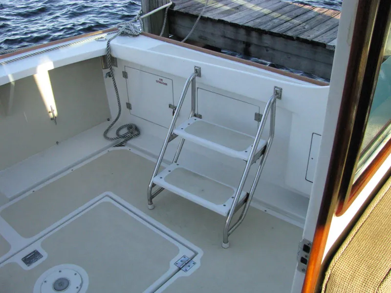 Slide: The Image of 1998 Duffy 35 Downeast Cruiser deck with ladder and dock view. - 14