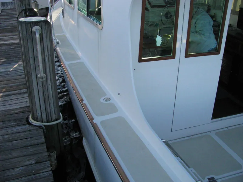 Slide: The Image of 1998 Duffy 35 Downeast Cruiser docked, showcasing sleek white exterior and wooden accents. - 15