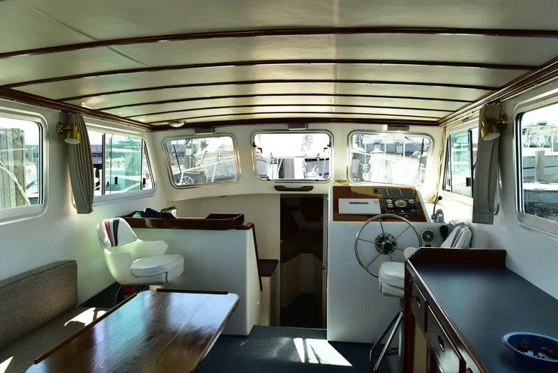 Slide: The Image of Interior of 1998 Duffy 35 Downeast Cruiser with helm, seating, and wooden table. - 19