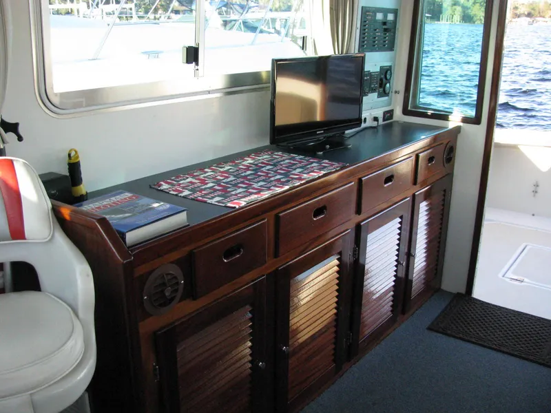 Slide: The Image of Interior of 1998 Duffy 35 Downeast Cruiser with wooden cabinetry and a small TV. - 23