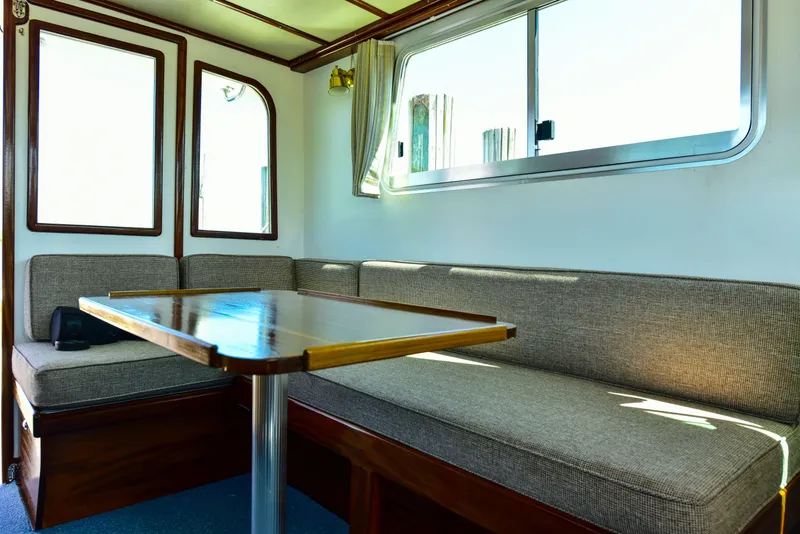 Slide: The Image of Interior of 1998 Duffy 35 Downeast Cruiser with cozy seating and wooden table. - 25
