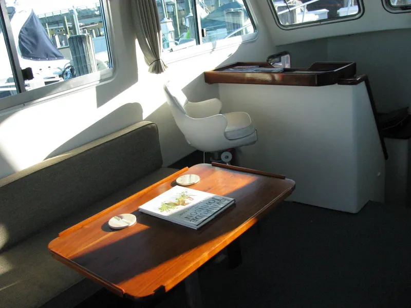 Slide: The Image of Interior of 1998 Duffy 35 Downeast Cruiser with wooden table and seating area. - 26