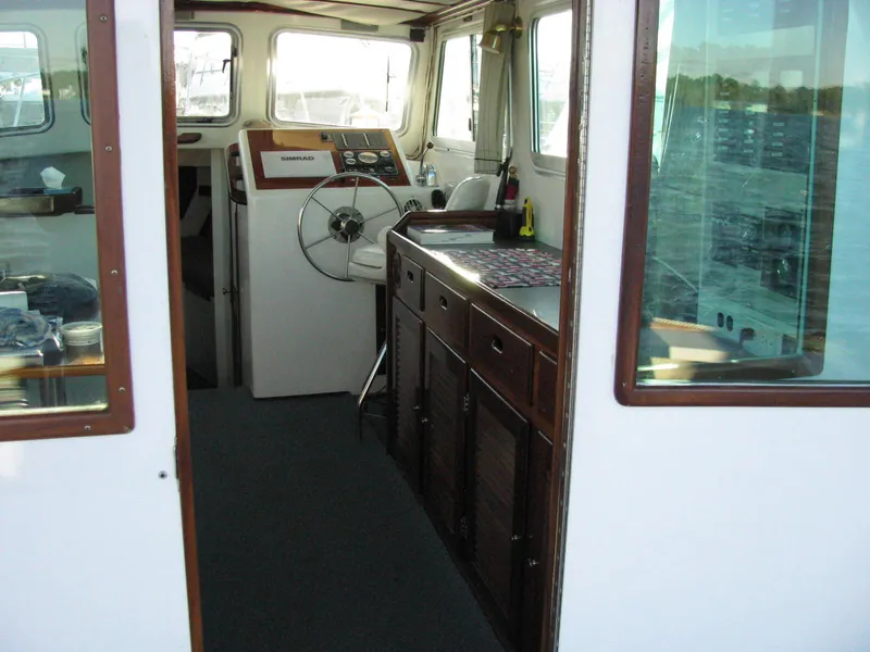 Slide: The Image of Interior of a 1998 Duffy 35 Downeast Cruiser with steering wheel and wooden cabinetry. - 28