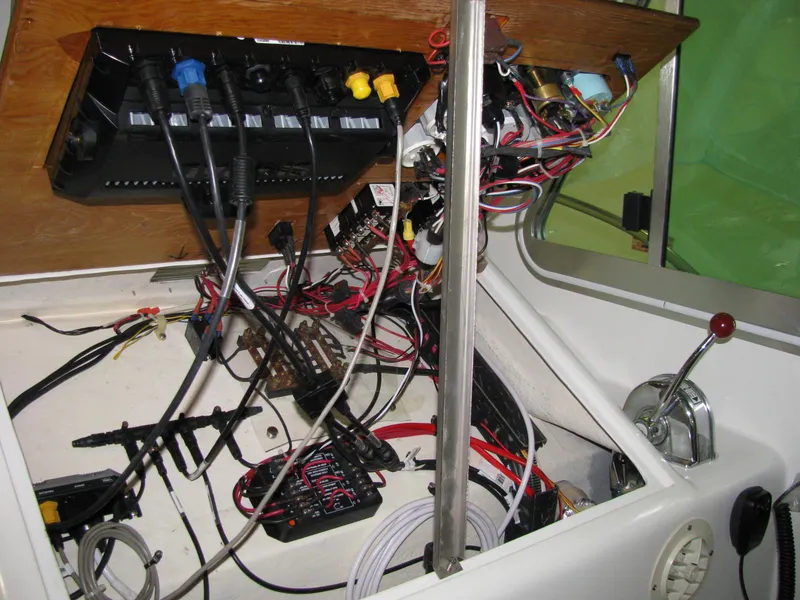 Slide: The Image of 1998 Duffy 35 Downeast Cruiser dashboard with exposed wiring and controls. - 32
