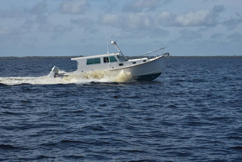 Slide: The Image of 1998 Duffy 35 Downeast Cruiser navigating open waters under a cloudy sky. - 4