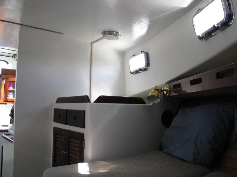 Slide: The Image of 1998 Duffy 35 Downeast Cruiser cabin interior with bed, storage, and portholes. - 53
