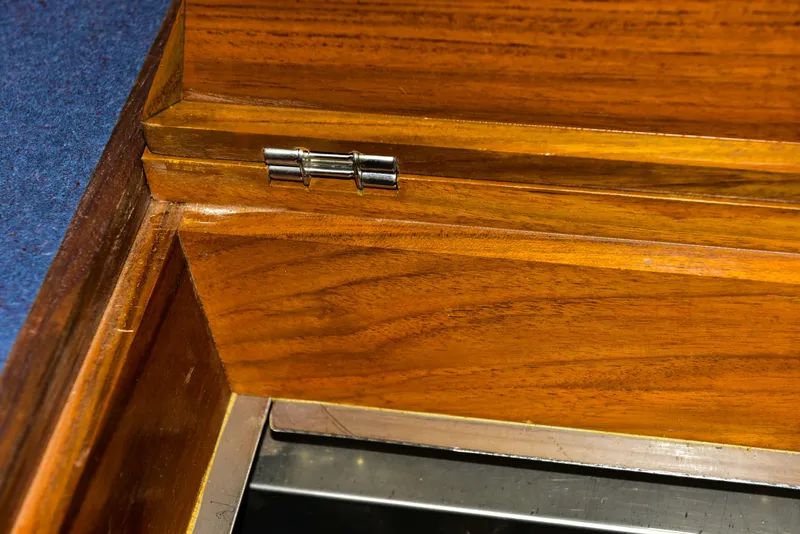 Slide: The Image of Wooden interior detail of a 1998 Duffy 35 Downeast Cruiser, featuring a metal hinge. - 54