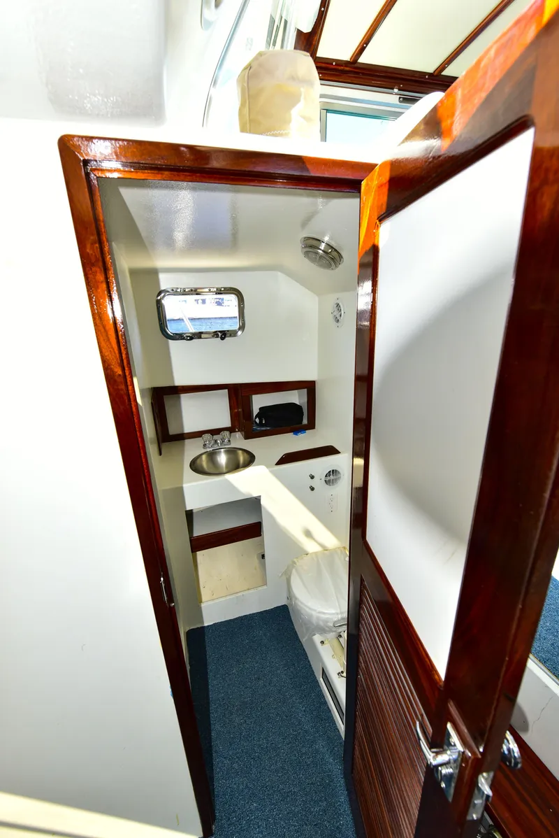 Slide: The Image of 1998 Duffy 35 Downeast Cruiser bathroom with wooden door, sink, and toilet. - 58