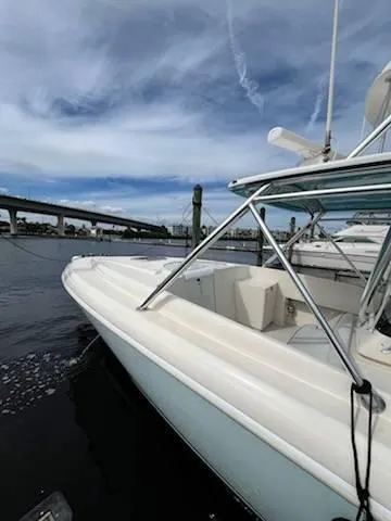 Slide: The Image of 2001 Intrepid 366 Cuddy boat docked by a bridge under a cloudy sky. - 14