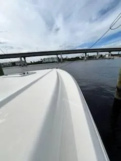 Slide: The Image of 2001 Intrepid 366 Cuddy boat docked by a bridge under a cloudy sky. - 17
