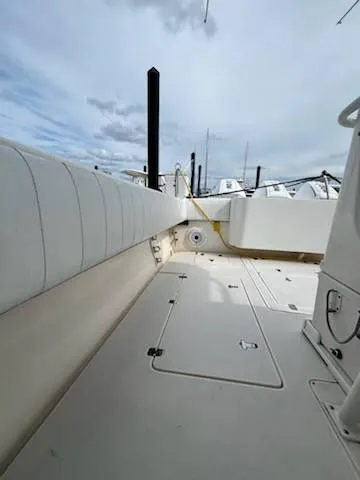 Slide: The Image of 2001 Intrepid 366 Cuddy boat deck with white seating and storage compartments. - 18