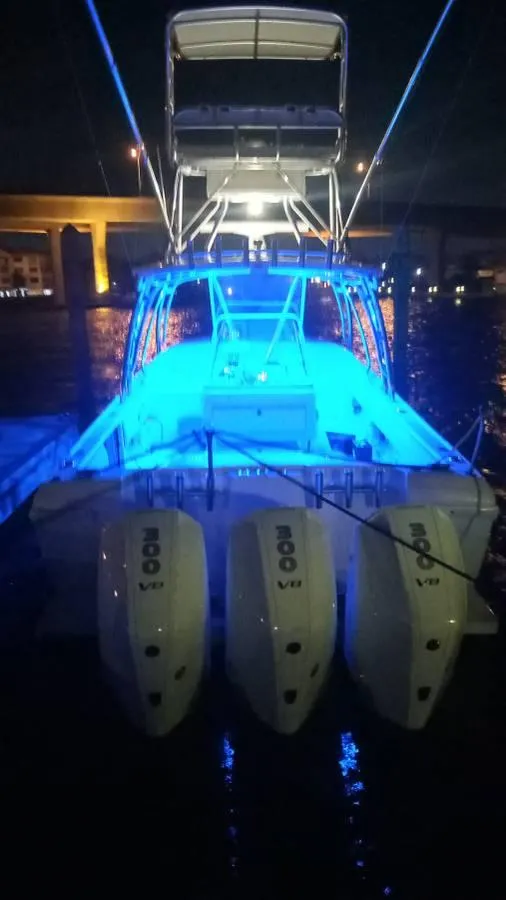 Slide: The Image of 2001 Intrepid 366 Cuddy boat with blue LED lights at night. - 21