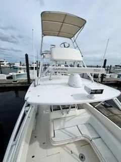 Slide: The Image of 2001 Intrepid 366 Cuddy boat docked at marina, featuring upper helm and canopy. - 22