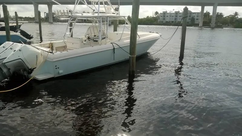 Slide: The Image of 2001 Intrepid 366 Cuddy boat docked on calm water under a bridge. - 8