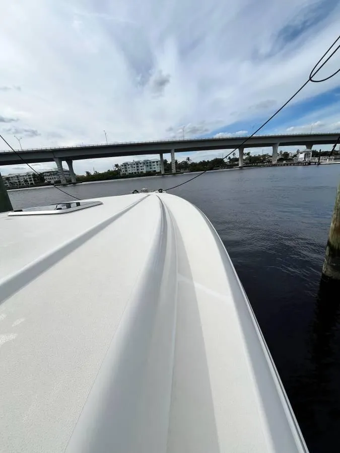 Slide: The Image of 2001 Intrepid 366 Cuddy boat on water near a bridge under a cloudy sky. - 9