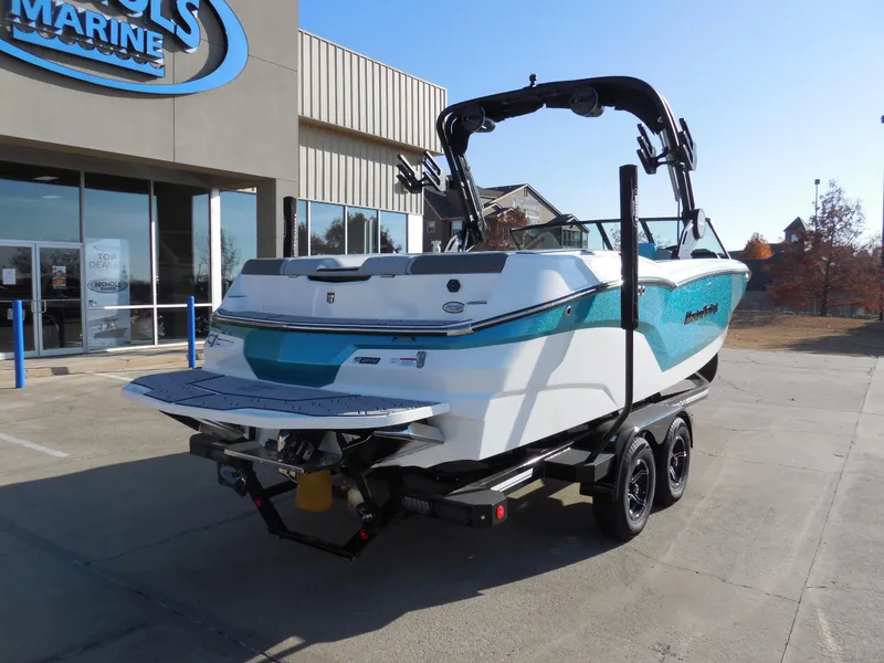 Slide: The Image of 2025 MasterCraft NXT24 boat on trailer outside dealership. - 3