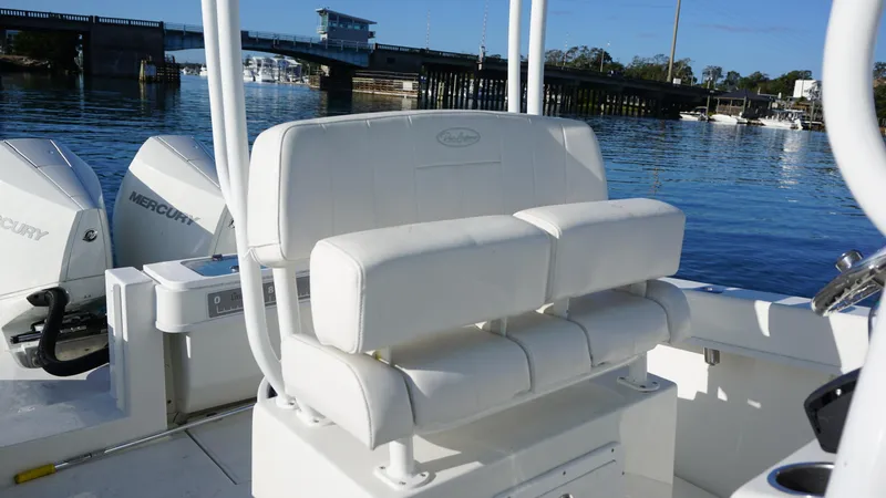 Slide: The Image of 2023 Pair Customs 25 Center Console boat with white seating, docked near a bridge. - 6