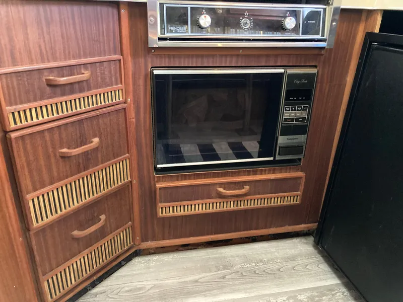 Slide: The Image of 1986 Sea Ray 340 Express Cruiser kitchen with wood cabinetry and built-in appliances. - 13