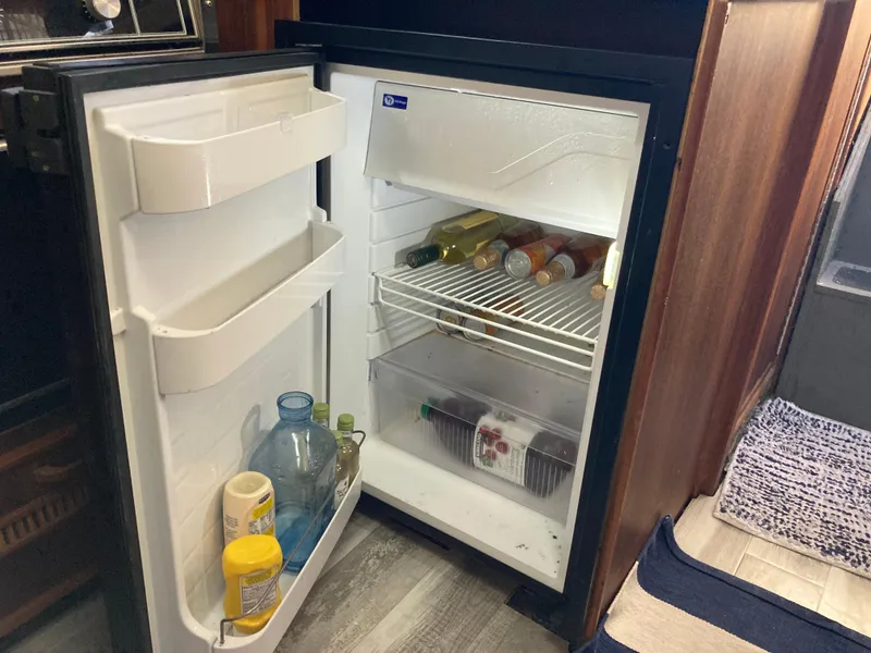 Slide: The Image of Open fridge in 1986 Sea Ray 340 Express Cruiser with drinks and condiments. - 16