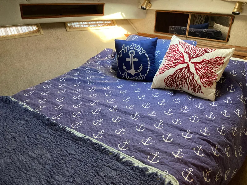 Slide: The Image of Cozy cabin interior of 1986 Sea Ray 340 Express Cruiser with nautical-themed bedding. - 19