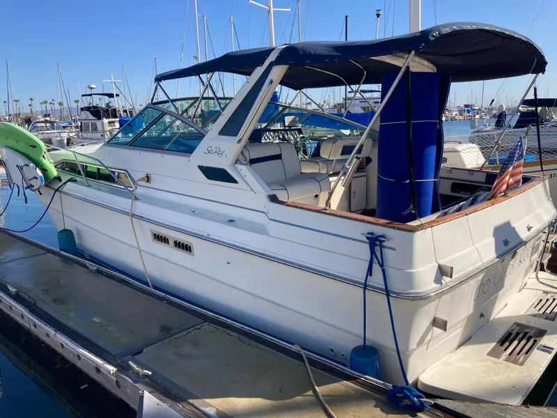 Slide: The Image of 1986 Sea Ray 340 Express Cruiser docked at marina, blue canopy, white hull. - 27