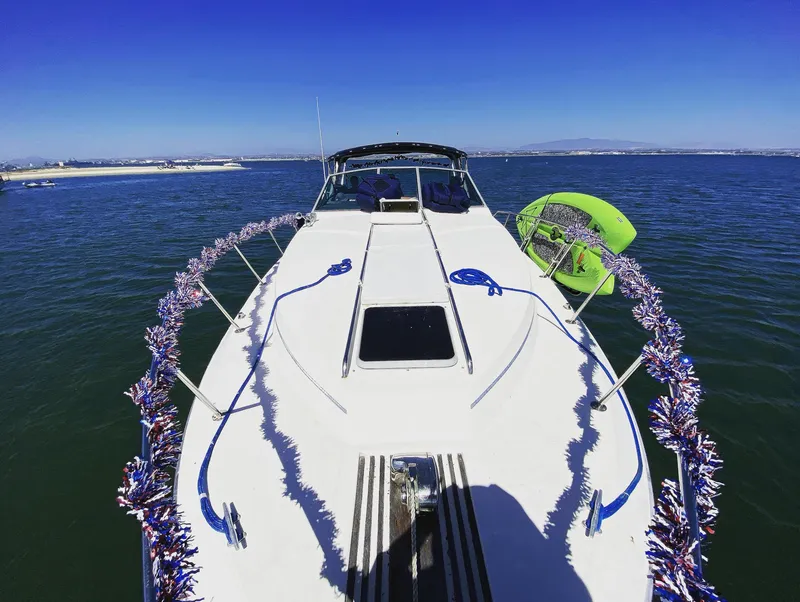 Slide: The Image of 1986 Sea Ray 340 Express Cruiser decorated with festive garlands on open water. - 30