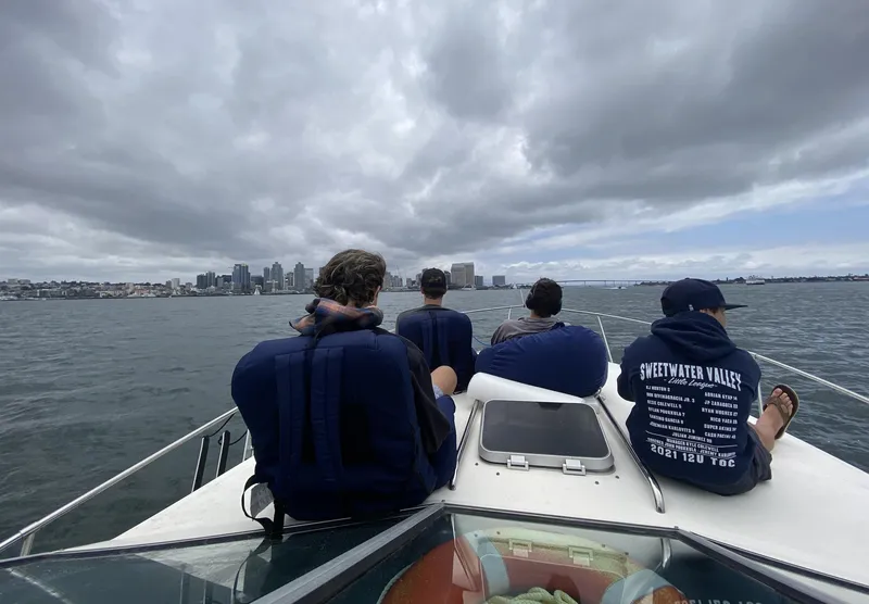 Slide: The Image of Four people on a 1986 Sea Ray 340 Express Cruiser, enjoying a cloudy day on the water. - 33