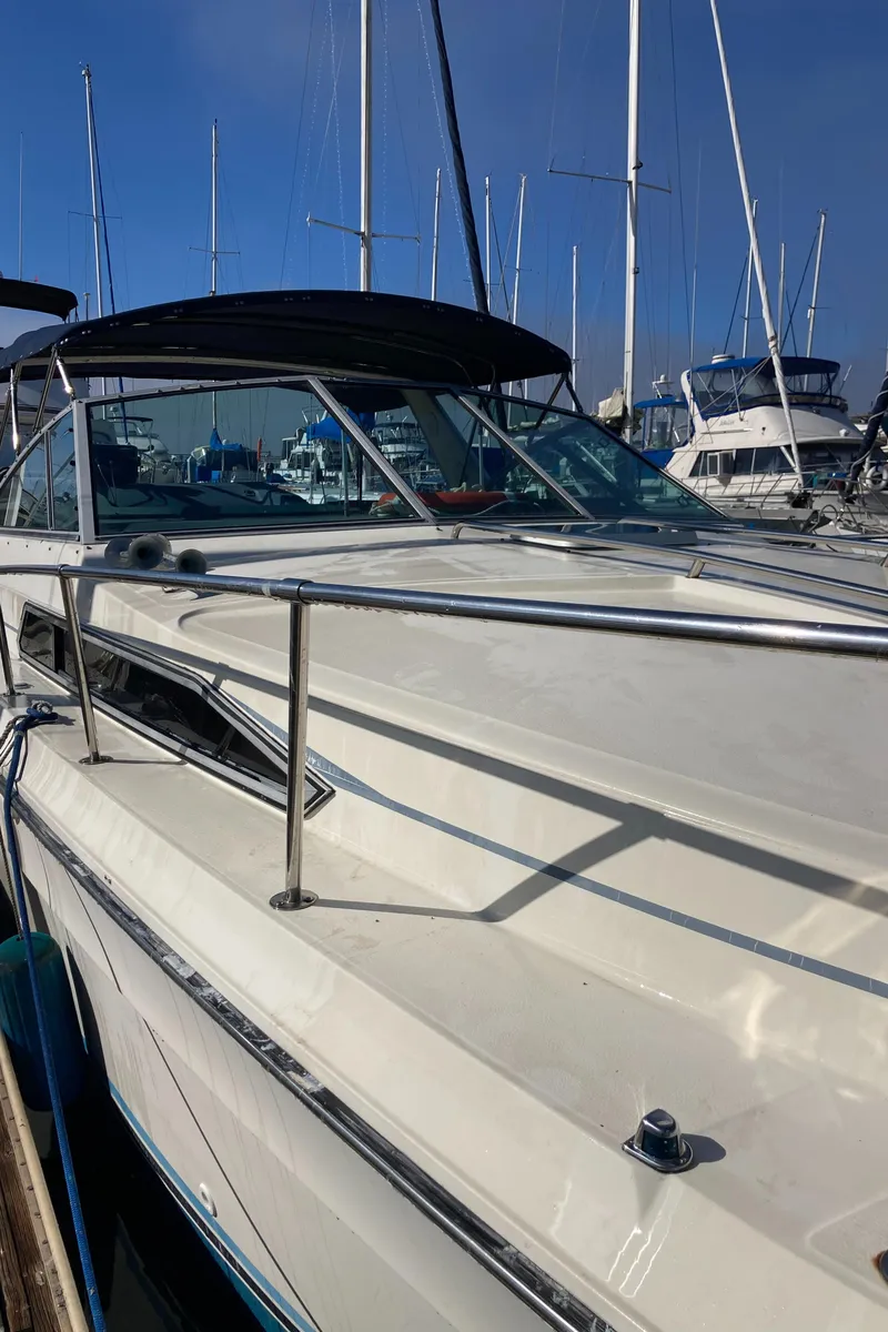 Slide: The Image of 1986 Sea Ray 340 Express Cruiser docked at marina, clear sky background. - 39