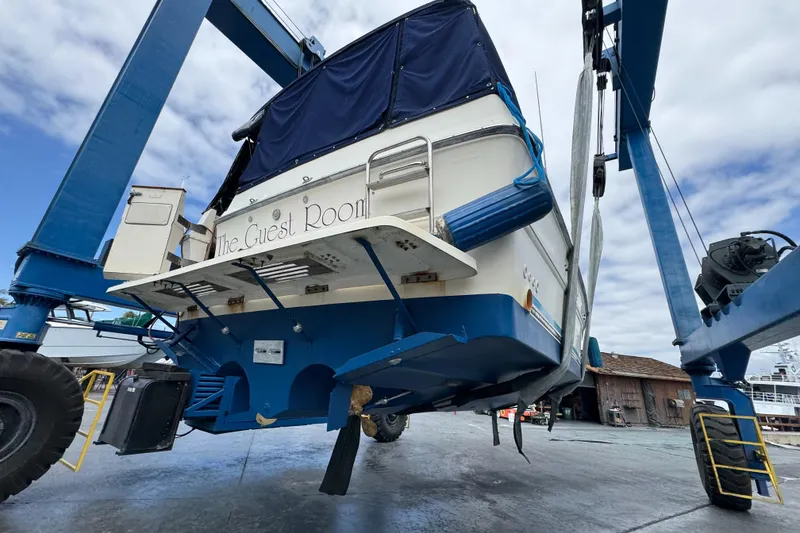Slide: The Image of 1986 Sea Ray 340 Express Cruiser on lift, showcasing hull and propeller. - 45