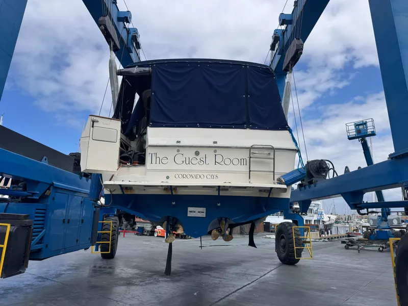 Slide: The Image of 1986 Sea Ray 340 Express Cruiser on lift, named "The Guest Room," at a marina. - 46