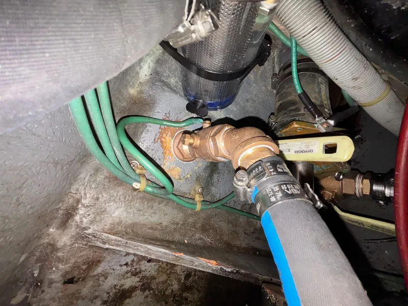 Slide: The Image of 1986 Sea Ray 340 Express Cruiser engine compartment with hoses and valves. - 49