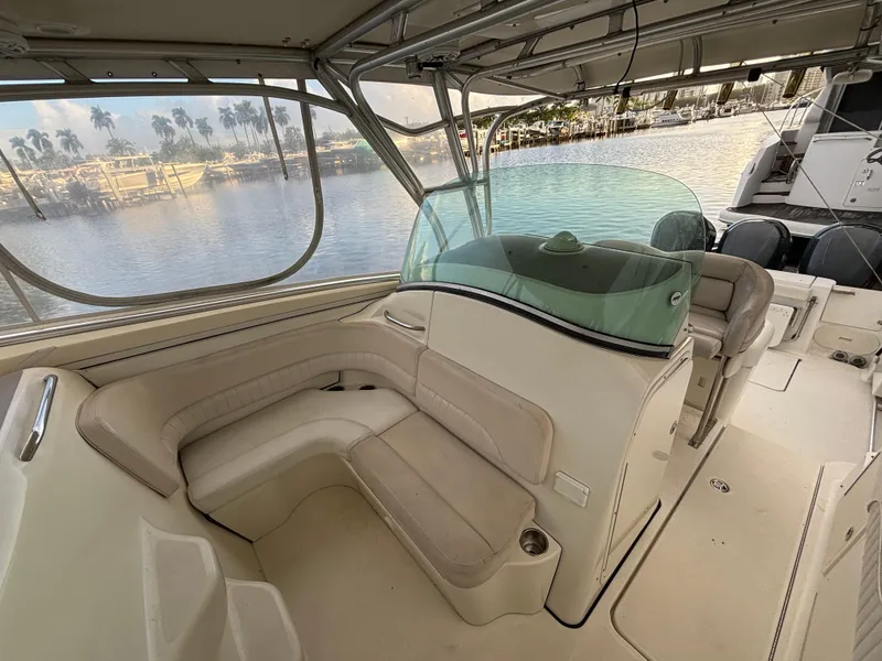 Slide: The Image of 2004 Hydra-Sports Vector 3300 VX boat interior with seating and windshield, docked by the water. - 3