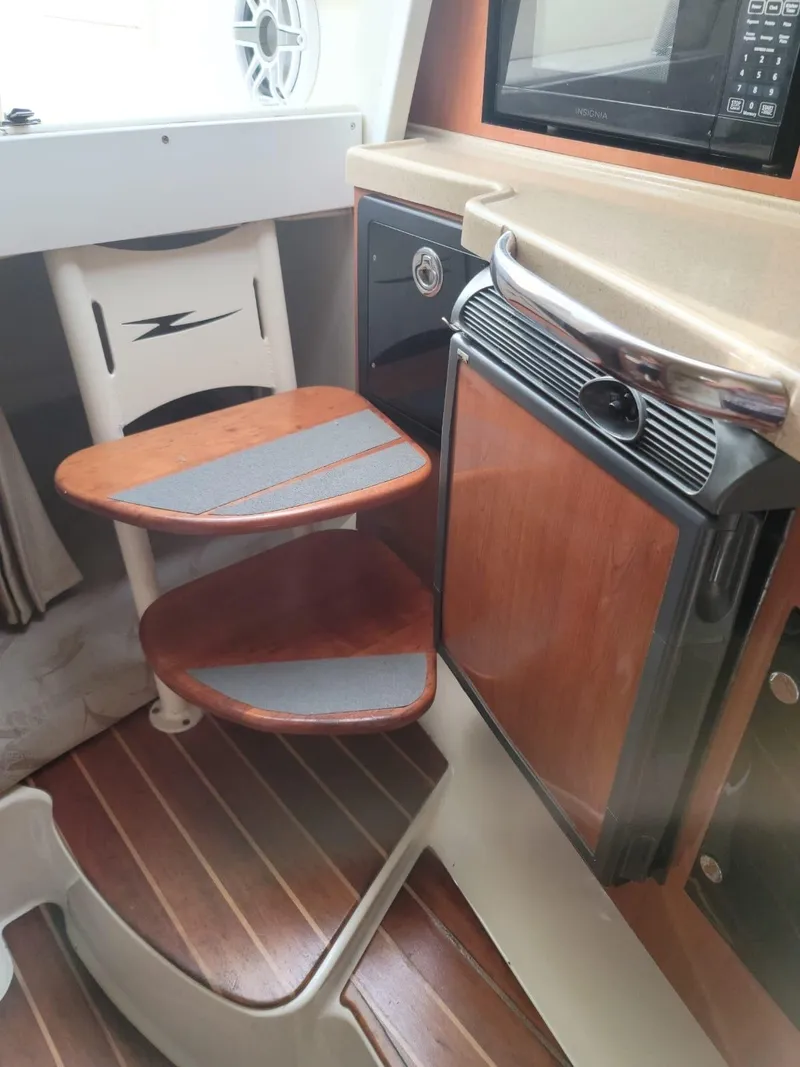 Slide: The Image of 2004 Hydra-Sports Vector 3300 VX cabin interior with compact kitchen and wooden steps. - 9