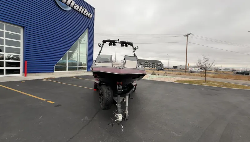 Slide: The Image of 2018 Axis Boats A22 parked outside a blue building on a cloudy day. - 4