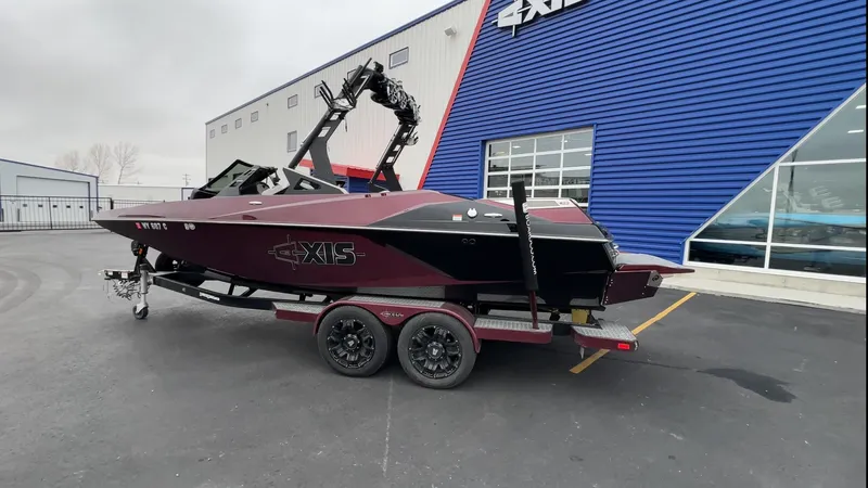 Slide: The Image of 2018 Axis Boats A22 on trailer outside dealership, featuring sleek black and maroon design. - 9