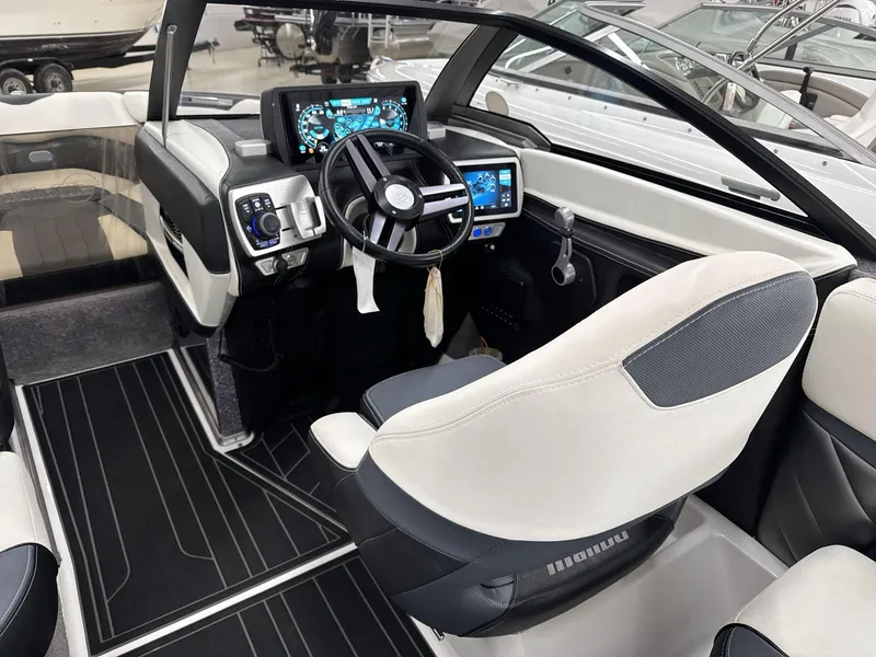 Slide: The Image of Interior of a 2016 Malibu 25 LSV boat with modern dashboard and steering wheel. - 12