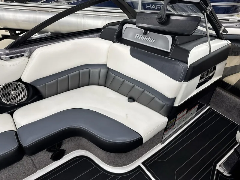 Slide: The Image of 2016 Malibu 25 LSV boat interior with sleek black and white seating. - 14